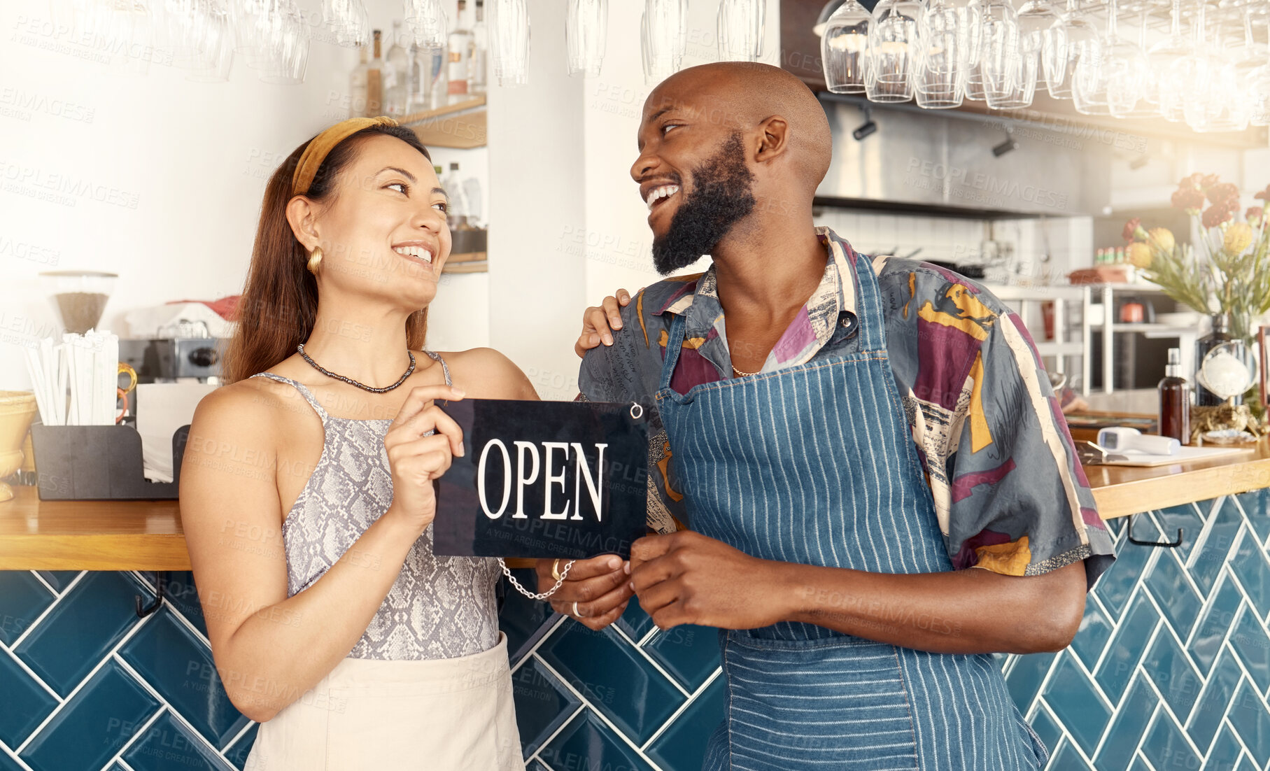 Buy stock photo Shot of two business colleagues working together holding an open sign