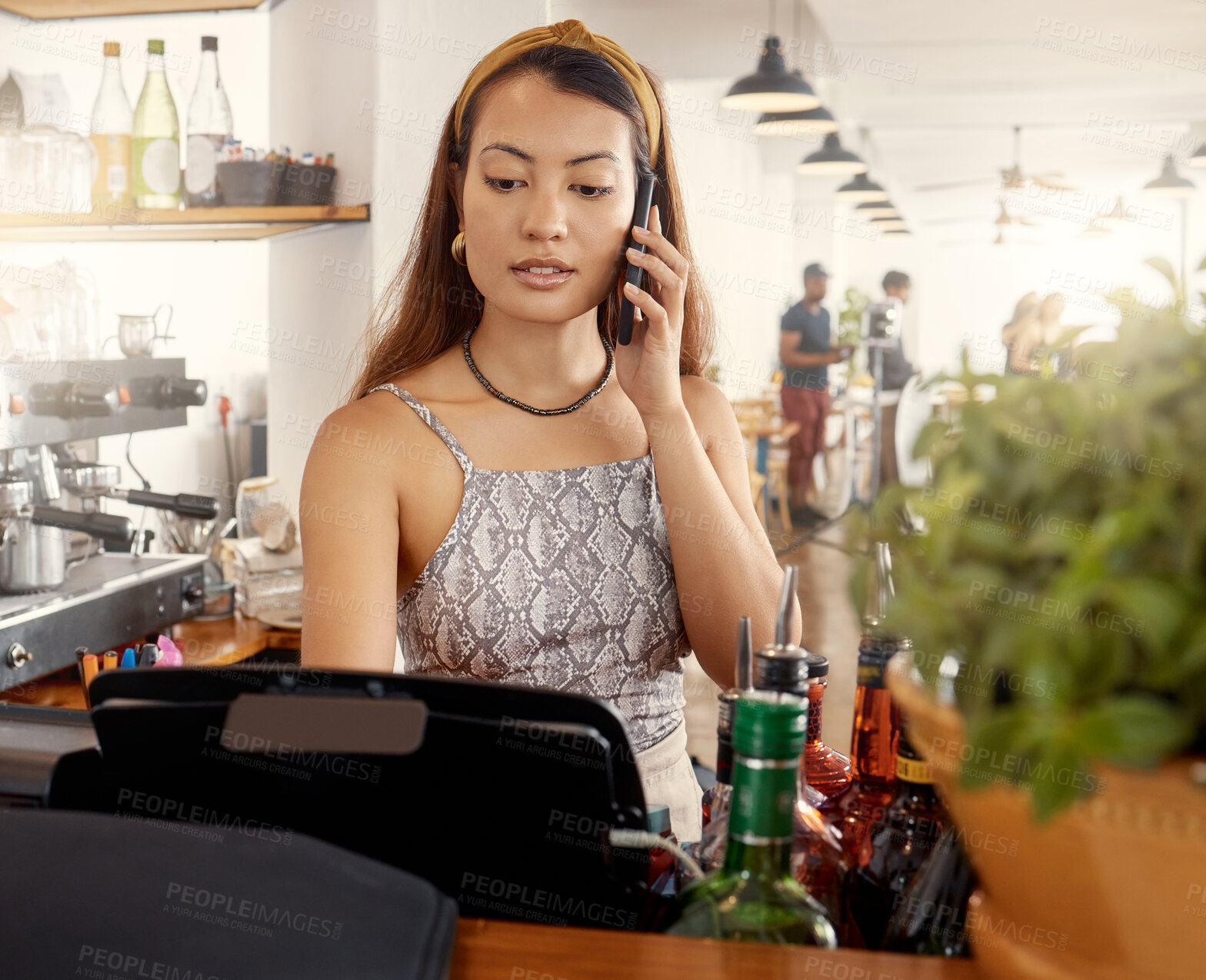 Buy stock photo Shot of a young business owner making a phone call while at work