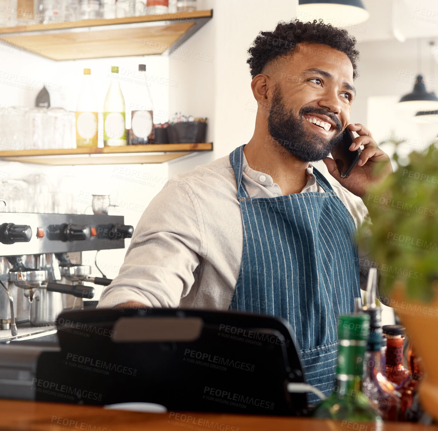 Buy stock photo Shot of a young waiter taking an order via his smartphone