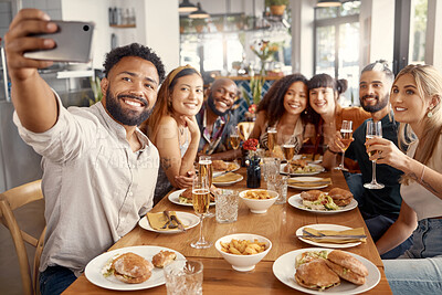 Buy stock photo Shot of a group of young friends taking selfies together at a restaurant