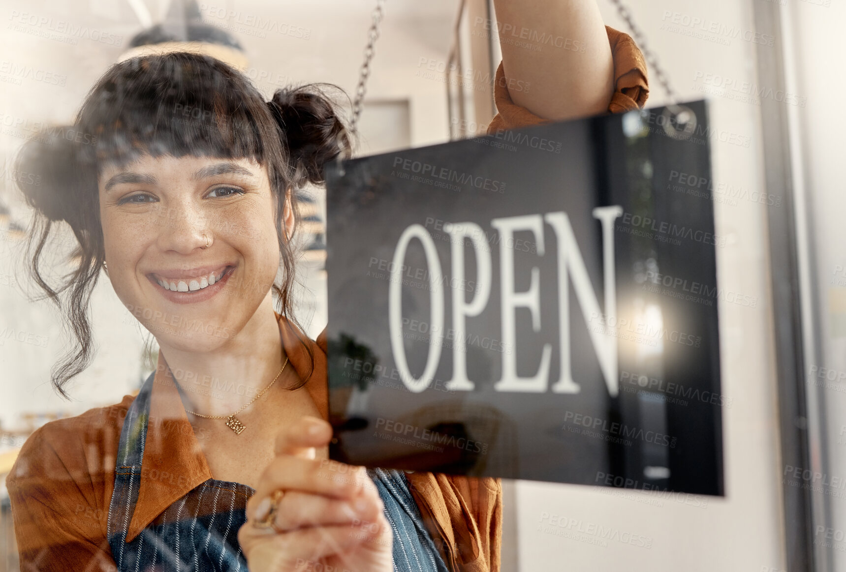 Buy stock photo Shot of a young business owner hanging up an open for business sign