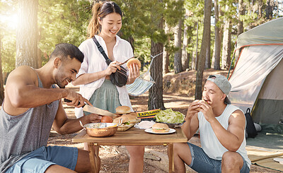Buy stock photo Friends, camping and lunch with young people in the forest for travel, adventure or to explore nature. Food, hiking and wilderness with a friendship group eating burgers together in the afternoon