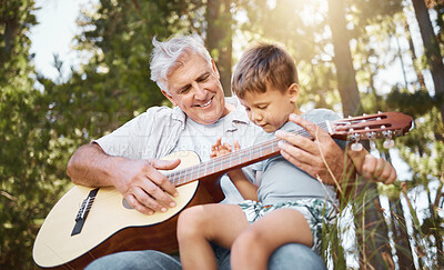 Buy stock photo Senior man, boy and forest with guitar, music and teaching for freedom, smile or outdoor in sunshine. Grandfather, instrument and male child with camping, learning or retirement on vacation in summer