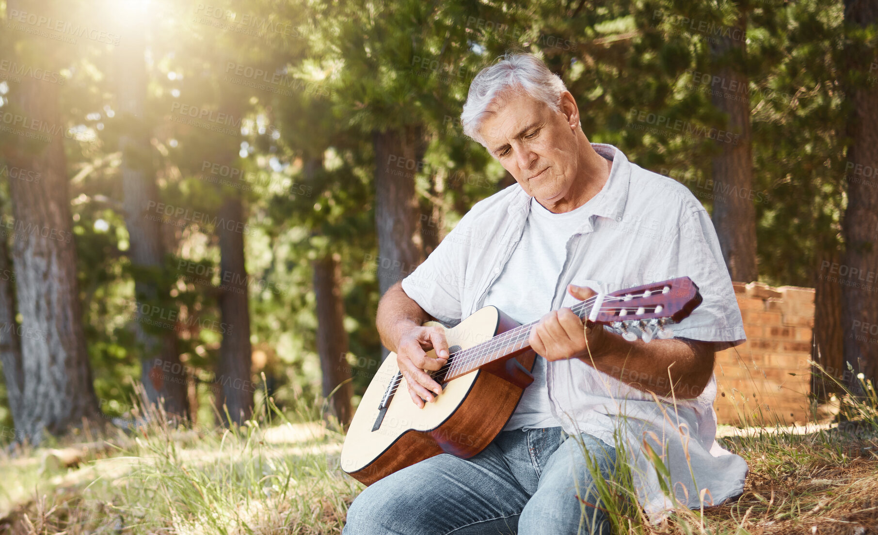 Buy stock photo Senior man, guitar and forest for camping, music and relax with freedom, peace and outdoor in summer. Elderly person, instrument and performance in woods, sunshine and retirement on holiday in nature