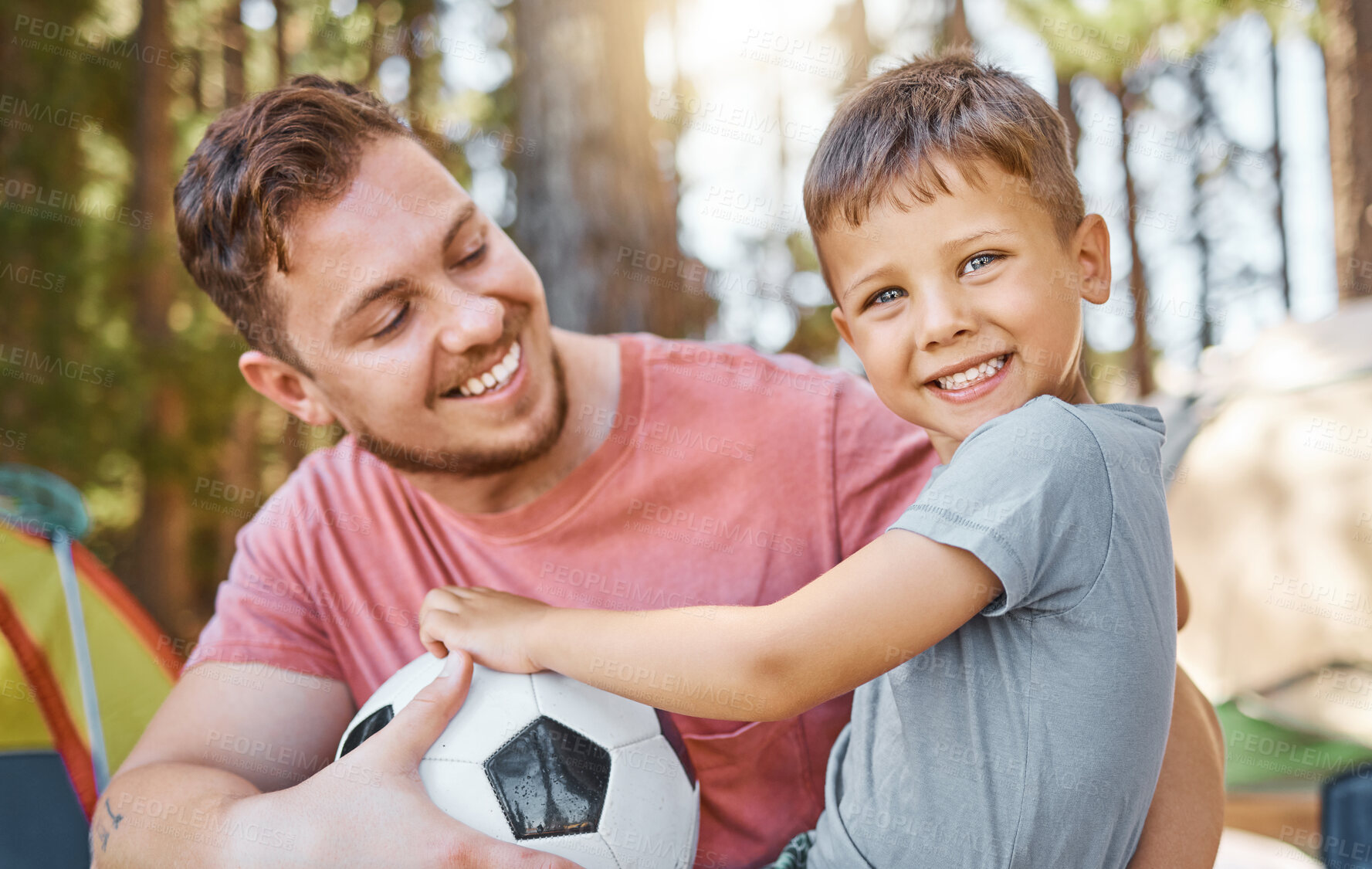 Buy stock photo Soccer, happy and camping with father and son in nature for bonding, playful and sports. Happiness, football and smile with portrait of child and man in forest for adventure, family and support