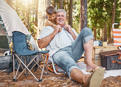 Buy stock photo Senior man, child and camping outdoor in nature with a smile, fun and family travel for summer holiday. Happy grandpa and kid camper on chairs at a camp site, forest or woods with love for adventure