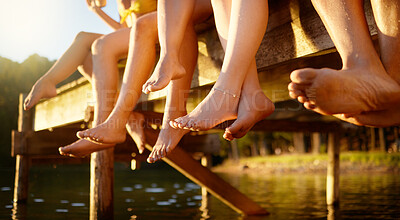 Buy stock photo Group, feet and friends together at lake, pier or outdoor in summer, vacation or freedom on holiday break. Teen, foot and children to relax at the water, harbor or barefoot at the river on weekend