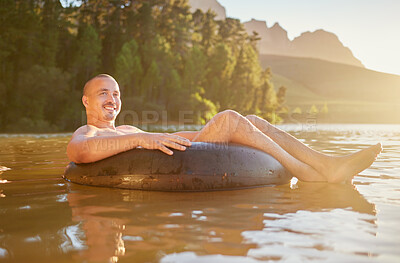 Buy stock photo Portrait, tube or happy man in lake to relax with carefree fun, peace or adventure weekend in summer. Smile, nature break or person in river water or dam to float outdoors on holiday or vacation trip