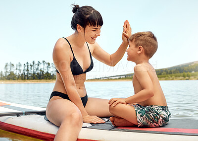 Buy stock photo Lake, mother and son on paddle board, high five and relax outdoor, summer holiday and travel. Adventure, freedom and fun, family with woman and boy child in swimsuit, vacation and bonding together