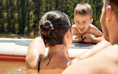 Buy stock photo Cropped shot of an affectionate young family of three having fun in the lake
