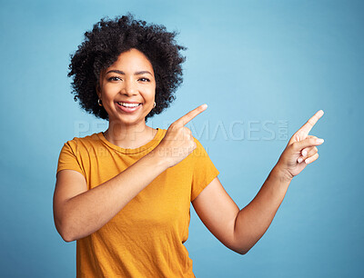 Buy stock photo Happy, portrait of woman pointing and against blue background for product placement. Direction or marketing, advertising or giveaway and female person pose with hand gesture in studio backdrop