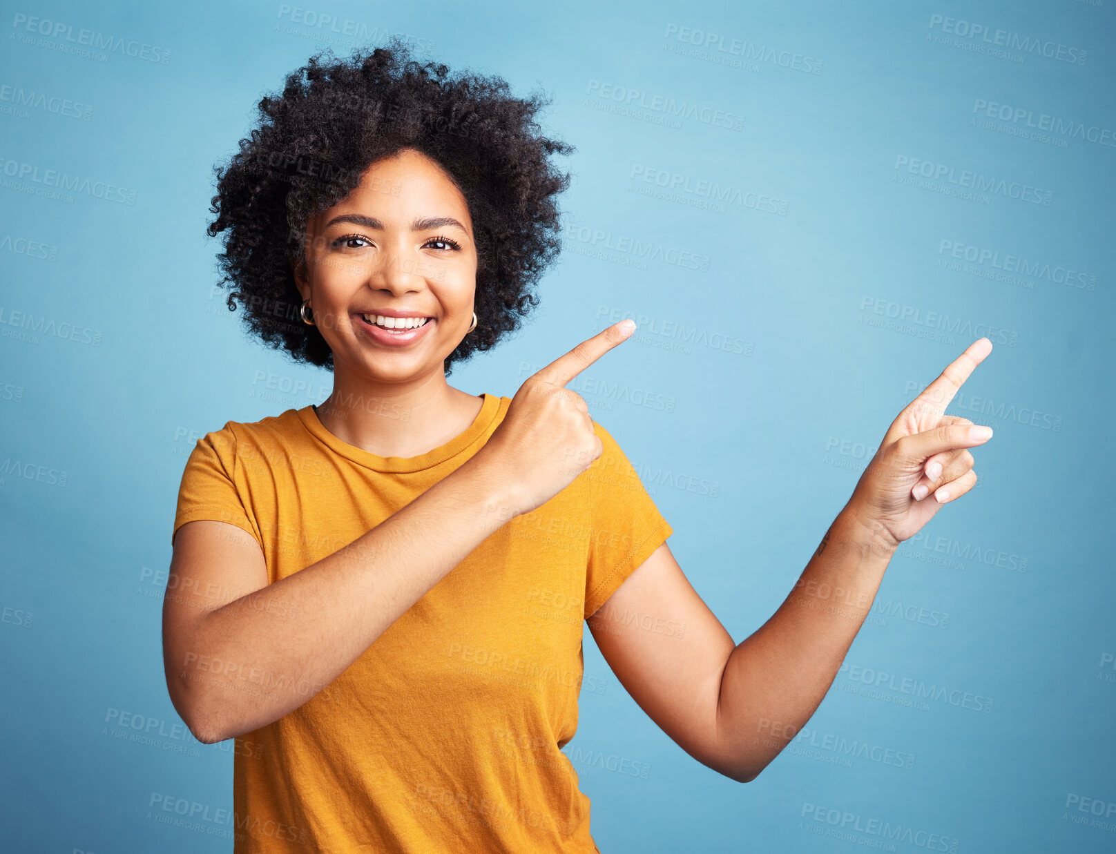 Buy stock photo Happy, portrait of woman pointing and against blue background for product placement. Direction or marketing, advertising or giveaway and female person pose with hand gesture in studio backdrop