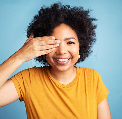 Buy stock photo Happy, cover eye and portrait of a woman for comedy, funny and vision check. Smile, confident and a young girl with a hand on face for positivity and a joke isolated on a blue background in studio