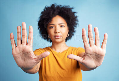 Buy stock photo Portrait, stop hands and serious woman in studio isolated on a blue background. African person, face and ban, rejection or warning, refuse and no palm sign to protest racism, human rights and emoji.
