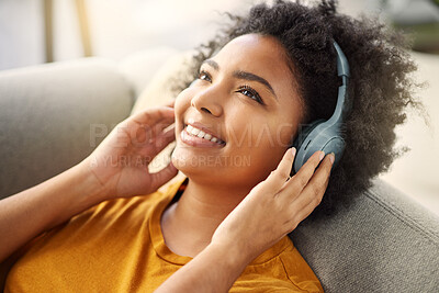 Buy stock photo Headphone, music and radio with girl on sofa for relaxing at apartment with smile on weekend. Song, woman and lying on coach with earphone with thinking for streaming with peace and calm at house.