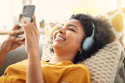 Buy stock photo Relax, couch and woman with a smartphone, headphones and home with happiness, stress relief and streaming music. Smile, female person or girl on a sofa, headset and chilling with a cellphone and song