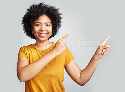 Buy stock photo Happy woman, portrait and pointing to advertising at white background, information offer and brand coming soon. Young female model gesture to sales announcement, commercial promotion and presentation