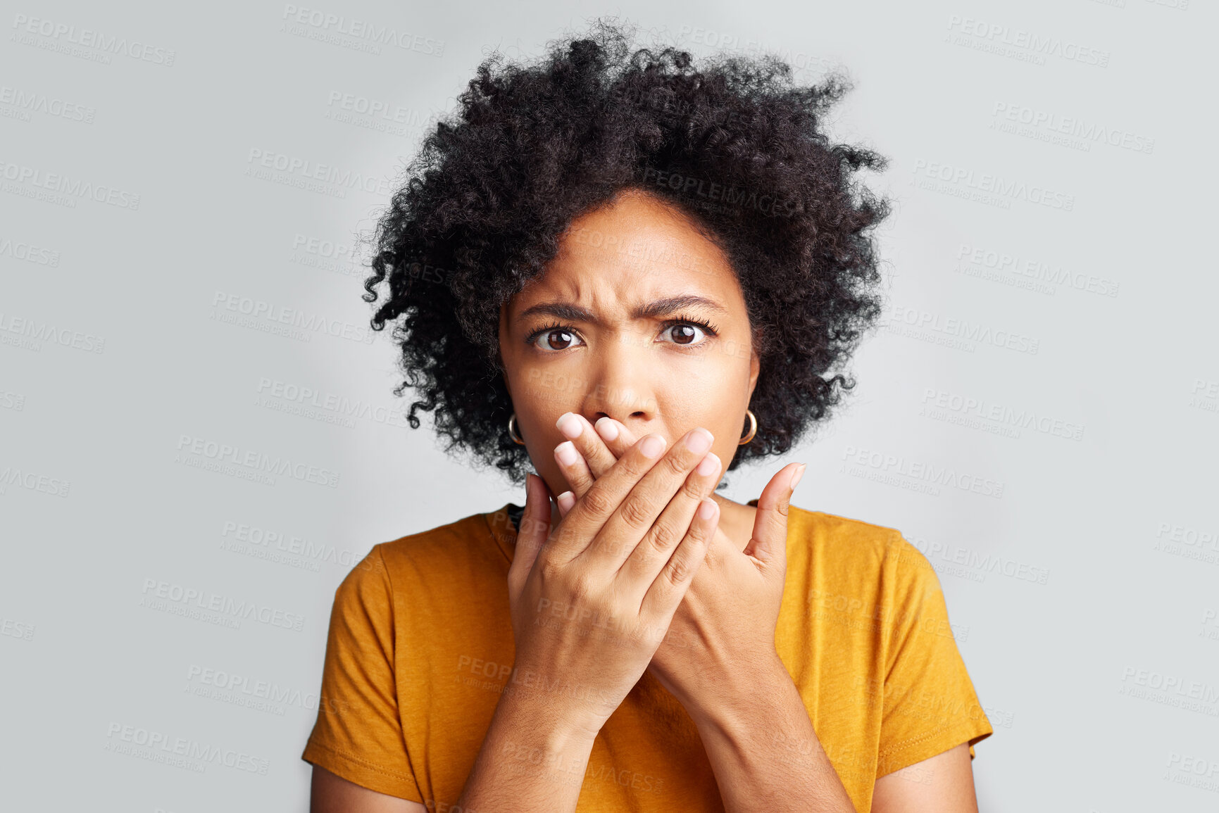 Buy stock photo Portrait, young woman and shocked with closed mouth or  crossed hands and wide opened eyes on gray background. Face, fear and girl holding secret or astonished with bad news or information