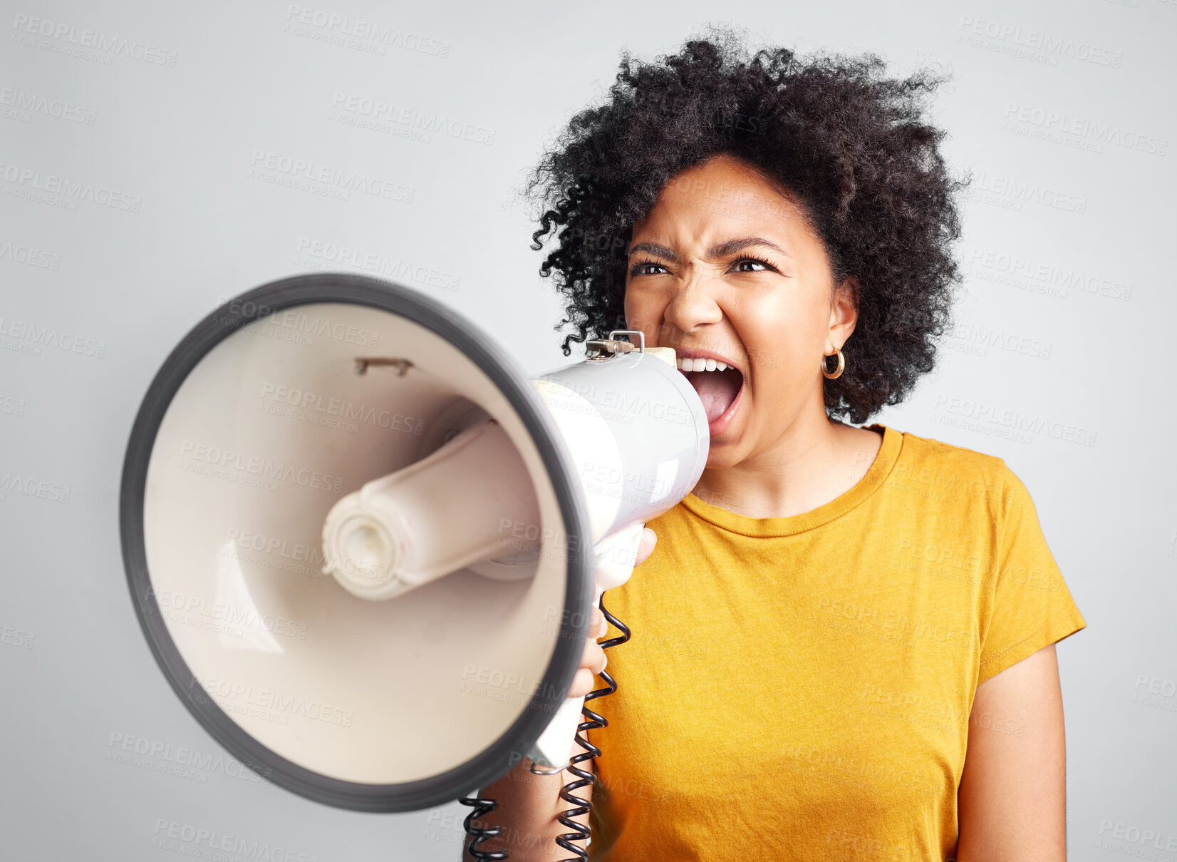 Buy stock photo Megaphone, speech and angry woman in studio for message, broadcast or screaming for freedom. Speaker, microphone and girl protest for change, democracy or justice or womens rights on grey background
