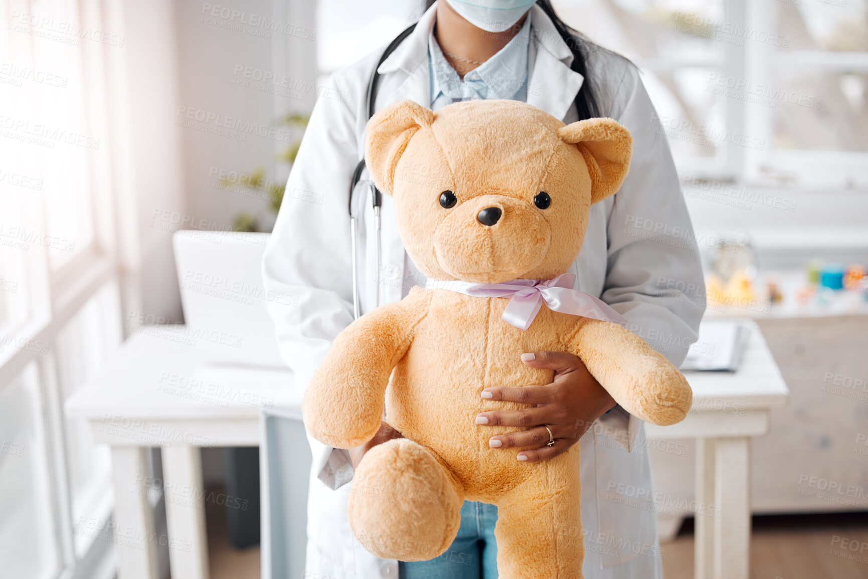 Buy stock photo Office, doctor and face mask with teddy bear in hospital or clinic for healthcare or wellness. Female person, pediatrician and baby toys for child medical services, advice or support with stethoscope