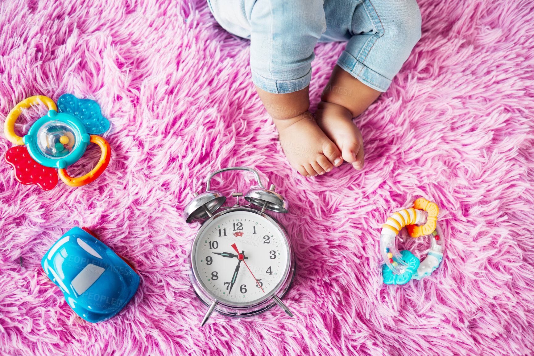 Buy stock photo Baby toys, infant and floor with clock for childcare, development and motor skills in family home. Toddler, feet and growth as little girl for curious, play and learning in safety, security and house