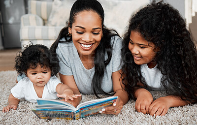 Buy stock photo Shot of a woman reading to her daughters