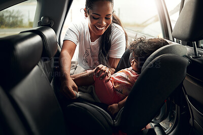 Buy stock photo Shot of a woman putting her baby into its car seat