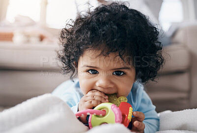 Buy stock photo Shot of an adorable little girl lying on the floor in the living room and playing with a toy