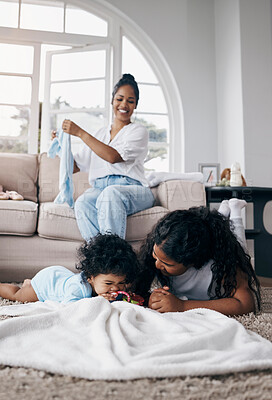 Buy stock photo Shot of an adorable little girl playing with her baby sister while their mother watches them at home