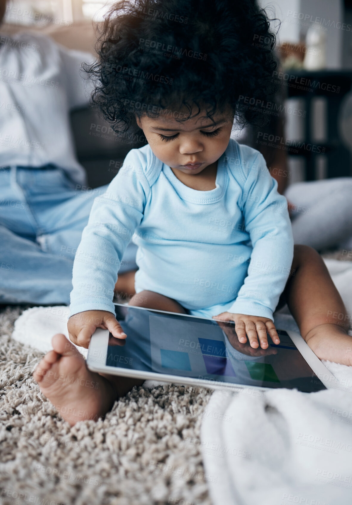 Buy stock photo Shot of an adorable little girl sitting on the living room floor at home and using a digital tablet