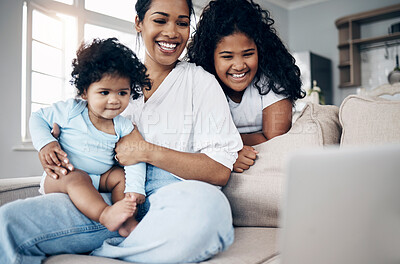 Buy stock photo Shot of a young mother using a laptop with her daughters on the sofa
