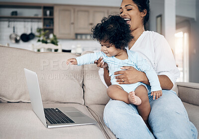 Buy stock photo Shot of a young mother using a laptop with her daughter on the sofa
