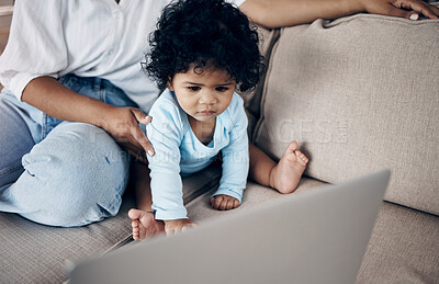 Buy stock photo Shot of an unrecognizable woman using a laptop with her daughter on the sofa at home