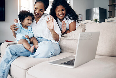Buy stock photo Shot of a young mother using a laptop with her daughters on the sofa