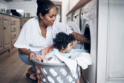 Buy stock photo Mother, baby and washing machine for laundry in home, helping mom and multitask with chores. Mama, support daughter and housekeeping with child in kitchen, cleaning and loading clothes in routine