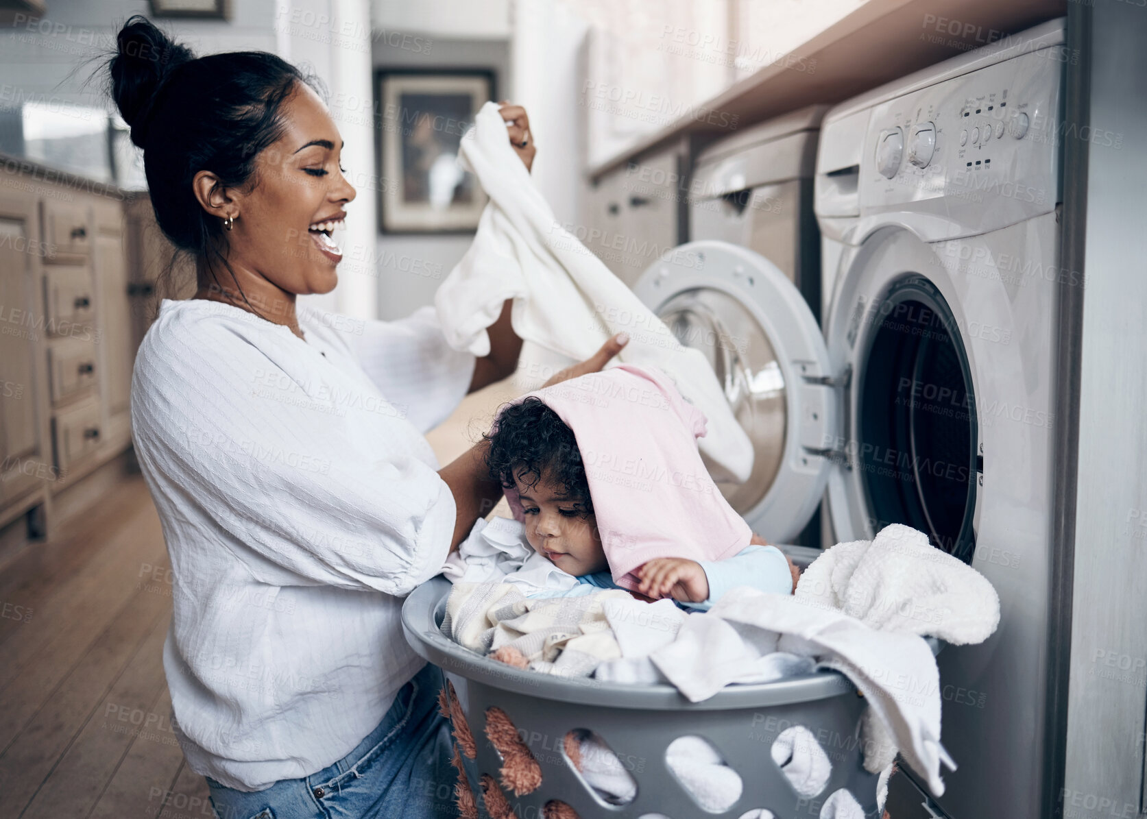 Buy stock photo Mother, baby and play with laundry basket in home, help mom and multitask with chores. Mama, support daughter and housekeeping with child in kitchen, cleaning and loading clothes in washing machine