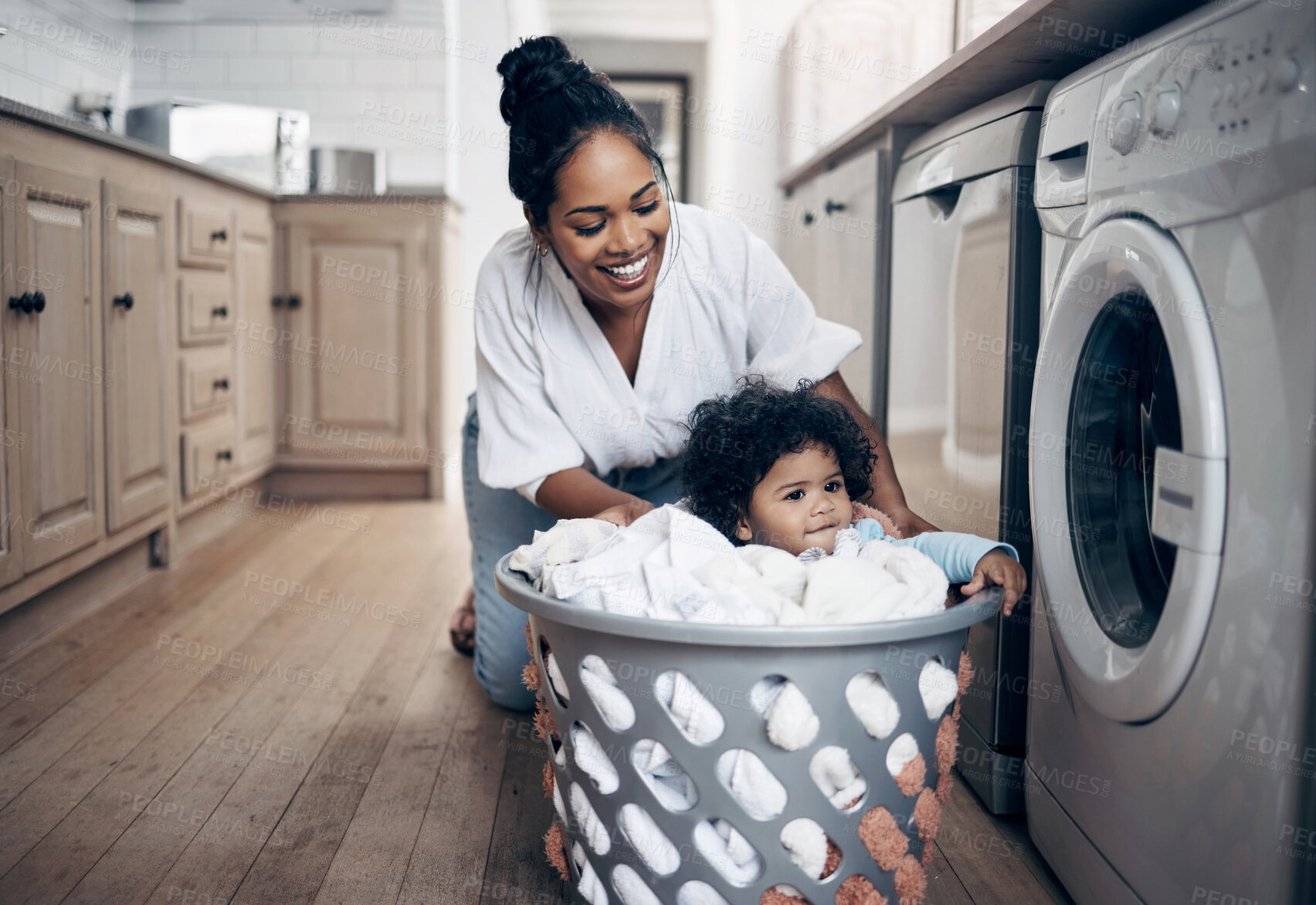 Buy stock photo Mother, baby and helping with laundry in home, multitasking and chores responsibility. Mama, infant daughter and housekeeping with child in kitchen, cleaning and loading clothes in washing machine