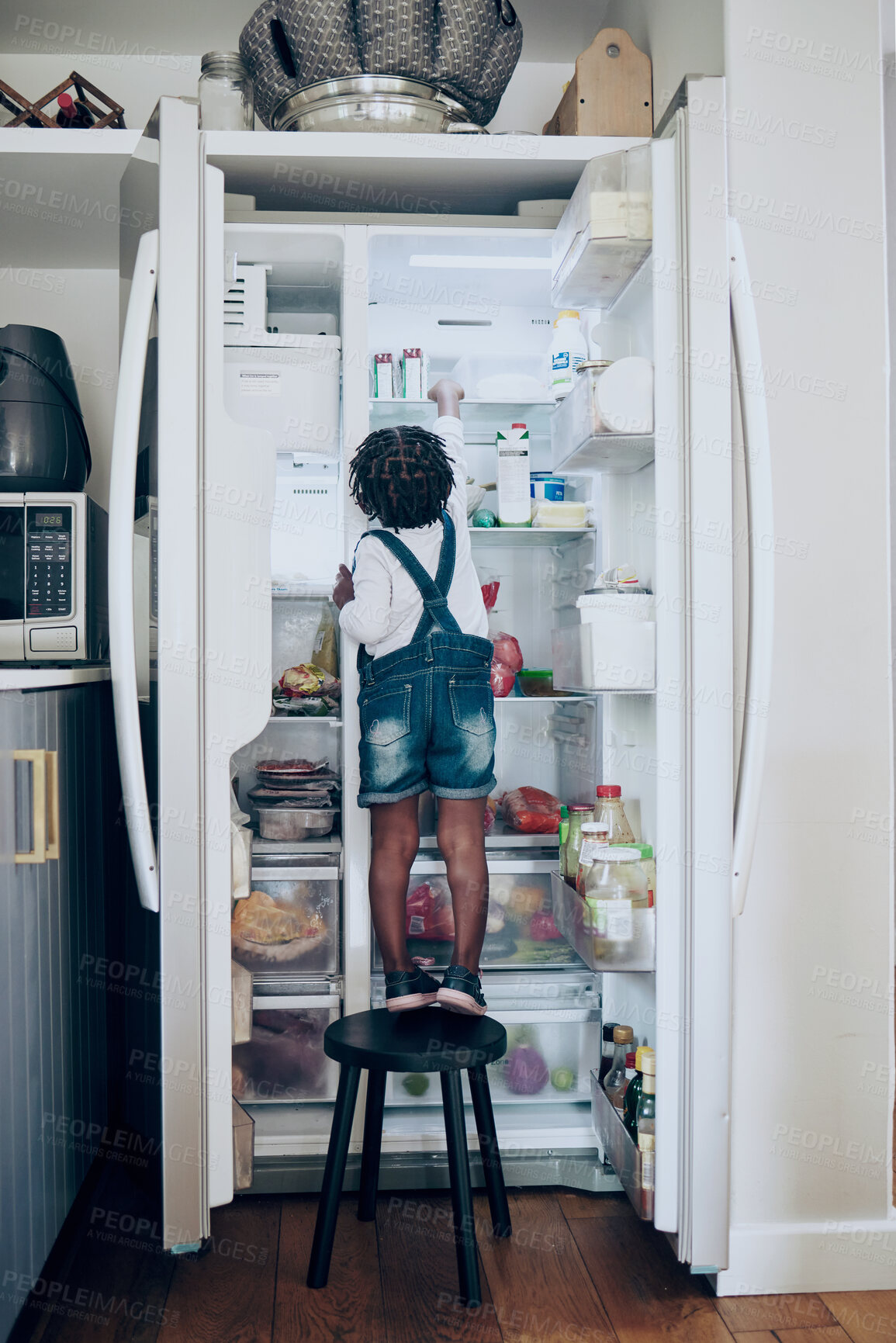 Buy stock photo Shot of a toddler taking food from the fridge at home