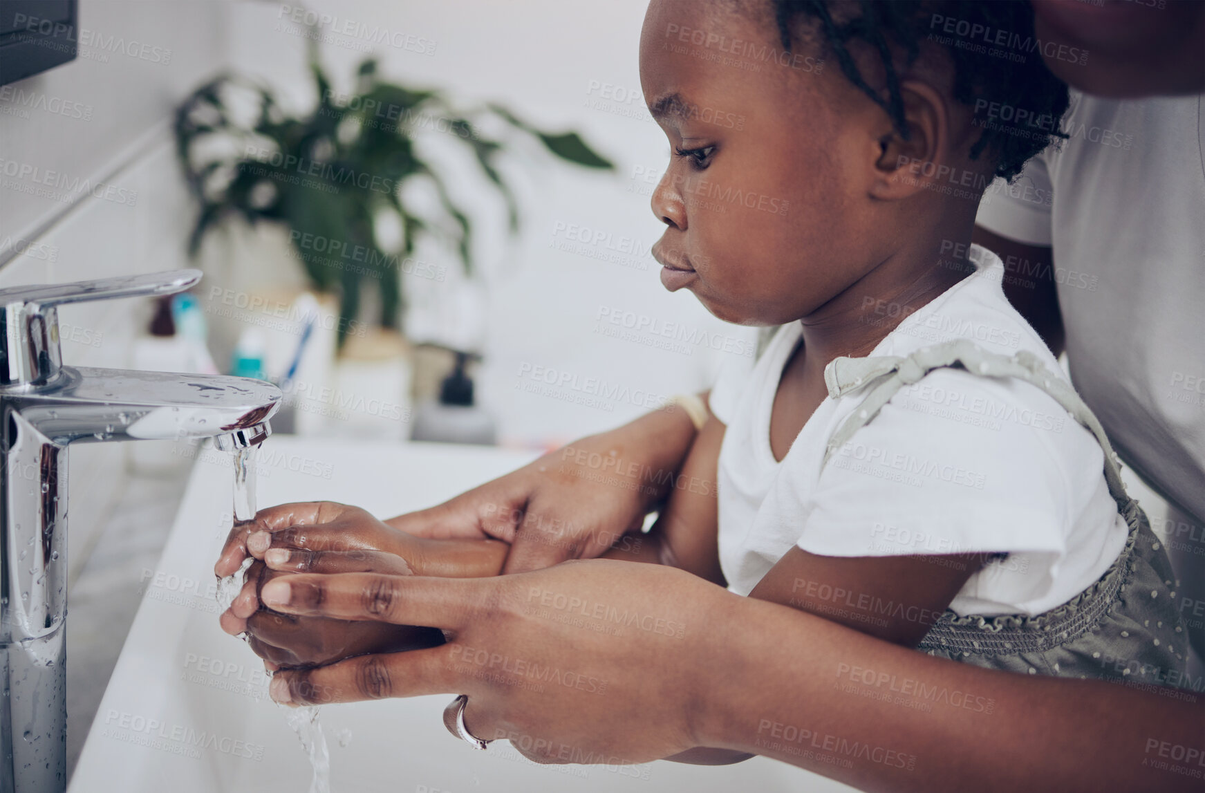 Buy stock photo Shot of a little gIrl washing her hands at home