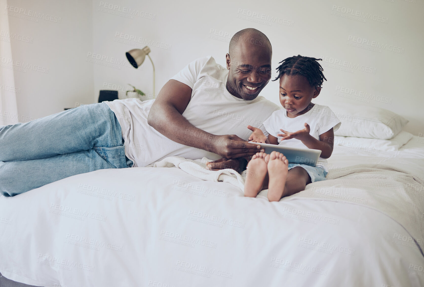 Buy stock photo Shot of a father and daughter using a digital tablet together at home