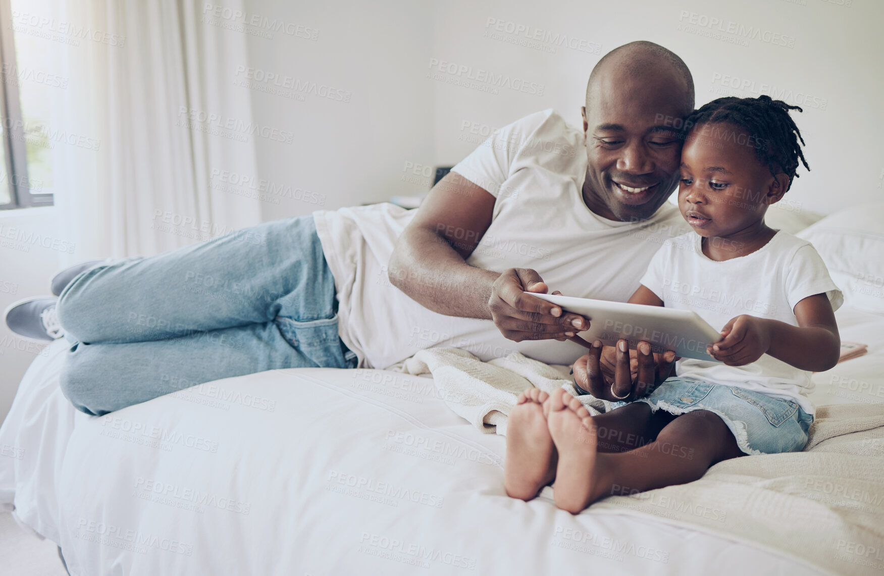 Buy stock photo Shot of a father and daughter using a digital tablet together at home