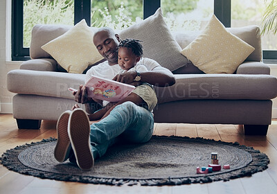 Buy stock photo Shot of a father reading a book with his daughter at home