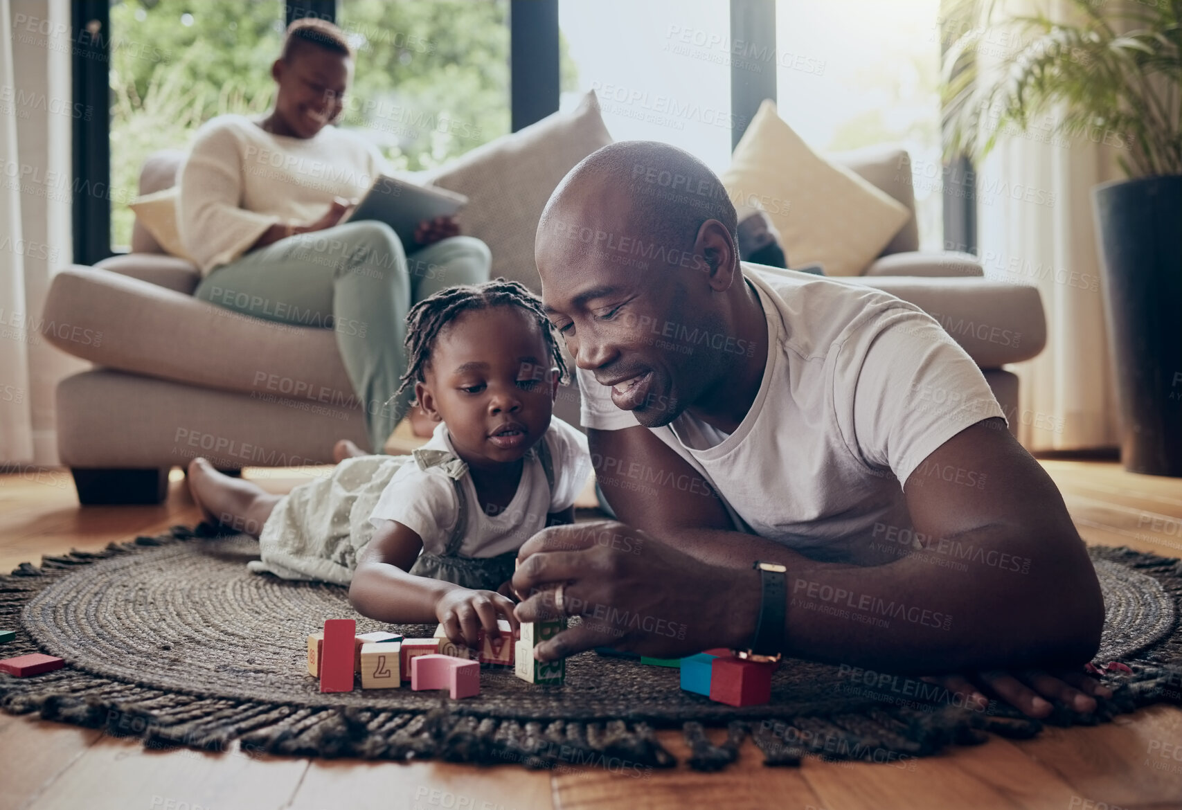 Buy stock photo Shot of a little girl and her father playing with blocks at home