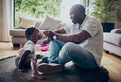 Buy stock photo Shot of a father feeding his daughter at home