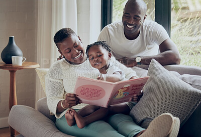 Buy stock photo Shot of a young family reading a book together at home