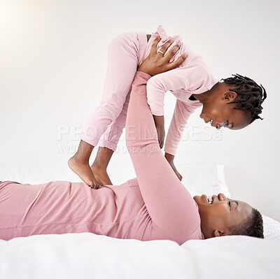 Buy stock photo Shot of a beautiful young woman bonding with her daughter in bed at home
