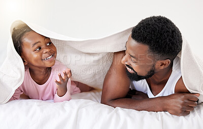 Buy stock photo Shot of a handsome young man bonding with his daughter in bed at home