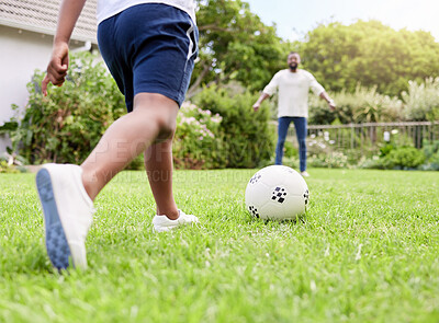 Buy stock photo Closeup shot of a little boy kicking a soccer ball to his father while playing together outdoors
