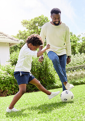 Buy stock photo Shot of a father and son playing soccer together outdoors
