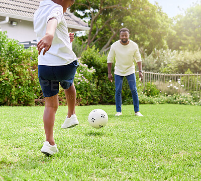 Buy stock photo Shot of a little boy kicking a soccer ball to his father while playing together outdoors
